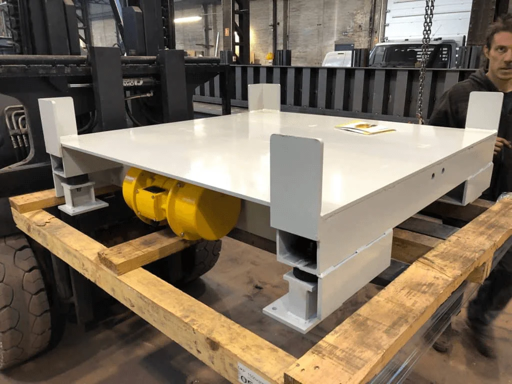 Table vibrante industrielle pour casser des cheminées dans des octabins afin de fluidiser le déchargement de la matière par canne d'aspiration